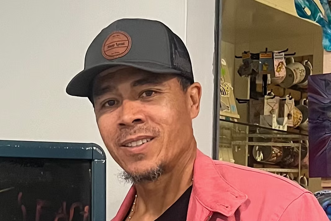 Humberto “Berto” Ramirez smiling in a gray cap and red jacket