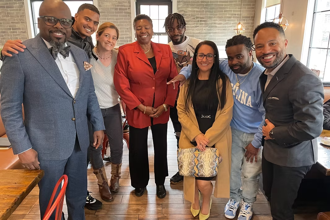 Group photo of advocates standing together in a restaurant after the parole preparation meeting